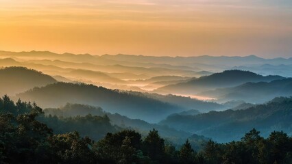 Obraz premium Layered mountains bathed in sunrise glow, with misty valleys and a warm orange sky. Concept Layered mountains at sunrise, Misty valleys in dawn light, Warm orange sky and golden hour