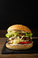 One smash burger with cheese on black background