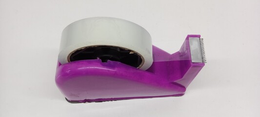 Close-up of clear duct tape with purple dispenser on white background