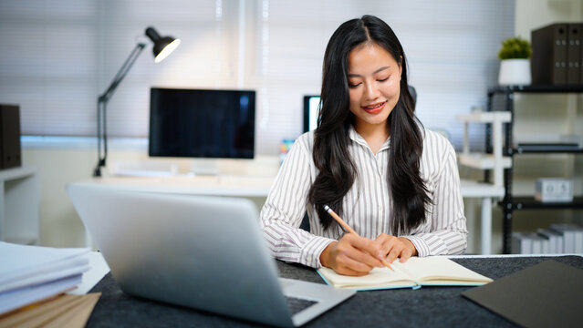 Writing, planning and computer with business woman in office, audit results and economy graph. Tax deadline, account manager and digital report with person in agency for budget review