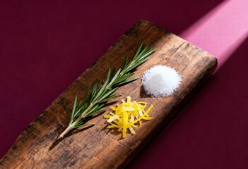 Culinary Palette: A culinary still life showcases the simple elegance of fresh ingredients on a wooden board. A sprig of rosemary, a mound of salt.