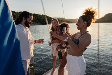Diverse friends enjoying boat party, celebrating during sunset