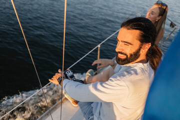 Man enjoying luxury vacation sailing on yacht during sunset