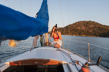 Woman sailing and photographing scenic sea views