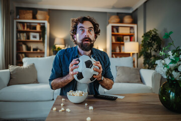 Stressed man watching football match at home