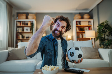 Man cheering, celebrating football victory at home