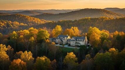 A grand house nestled amidst rolling hills ablaze with autumn's vibrant hues at sunset