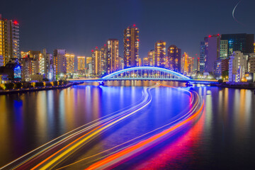 Obraz premium 夜の隅田川の航跡と永代橋の夜景