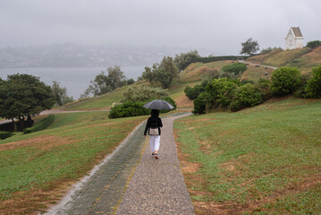 Woman walking with an umbrella on La Colline Sainte-Barbe. Saint-Jean-de-Luz. French Basque Country