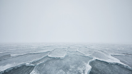 Freezing lake covered with snow under overcast sky during winter