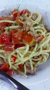 Classic spaghetti aglio e olio with tomato, chili flakes garlic and parsley