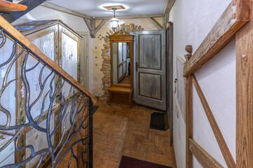 Rustic Hallway Interior with Wooden Staircase and Vintage Mirror