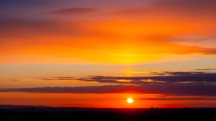 Sunset over hills and buildings vibrant gradient of orange red purple and deep blue sky