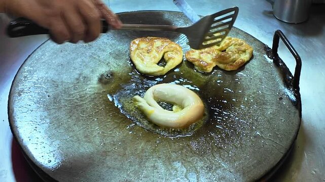 Street Vendor Flipping Thai Roti Pancake on Metal Panc