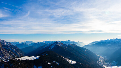 Fototapeta premium View to Pinzolo village in the valley of Italian Alps mountains during ski resort winter season, sport and tourism