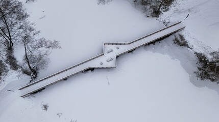 Aerial View of Snow-Covered Wooden Bridge Over Frozen Lake