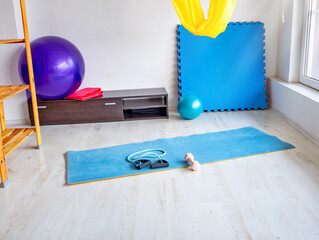 Yoga mat with fitness accessories in bright studio interior