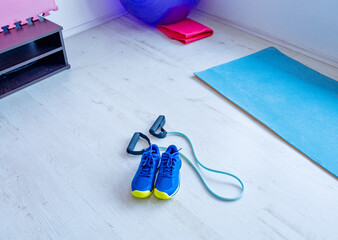 Sports shoes and resistance band on gym floor
