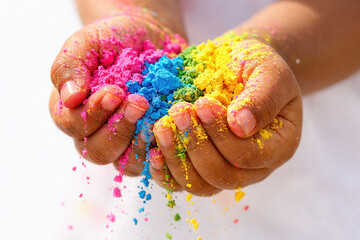 Vibrant holi celebration with hands holding colorful powders in close-up view