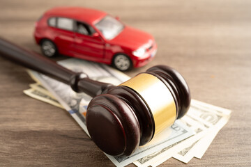 Hammer gavel judge and US dollar banknote money with car vehicle accident, insurance coverage claim lawsuit court case.