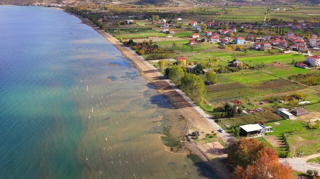 Aerial video of Pogradec akeside in Albania with farmlands and calm shoreline. 