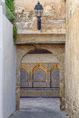 Bab el-Assa (Gate of Beatings) framing a beautiful tiled bench of intricate traditional Moorish zellij mosaic and ornate plaster. Tangier-Morocco-008