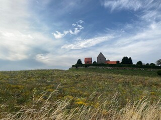 Autumn Meadow with Flowers and Historic Church on Bornholm Island, Denmark
