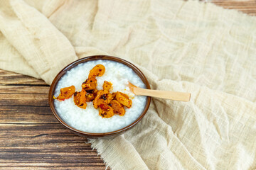 Fototapeta premium The white rice porridge and red oil dried radish in the porcelain bowl