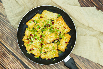Fried tofu is placed in a frying pan