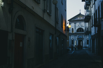 Street of an Italian city with a church in the background
