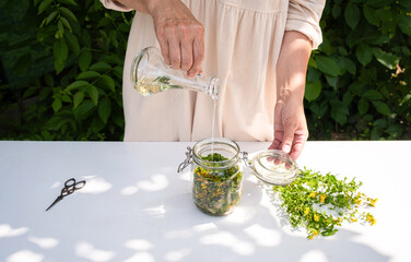 St. John's Wort Oil Recipe Step 9: Woman Pouring Oil into Filled Jar