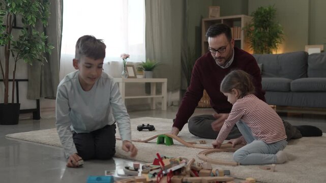 Happy father and children playing video games at home