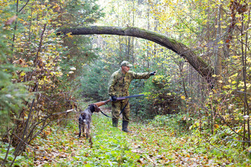The hunter explains his hunting dog where to look for game