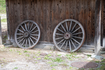 日本の農家の納屋に立てかけられた荷馬車の車輪
