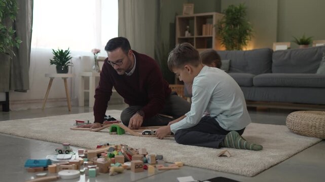 Happy father and children playing video games at home