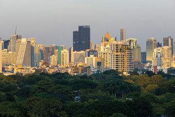 Modern office building and condominium with green tree Lumphini park sunset sky