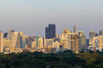 Modern office building and condominium with green tree Lumphini park sunset sky