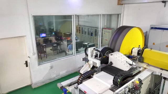 Automated roll material processing equipment operating inside a factory workshop