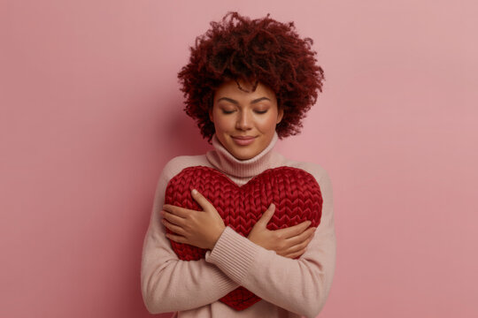 Young woman hugging a heart shaped for self love concept 

