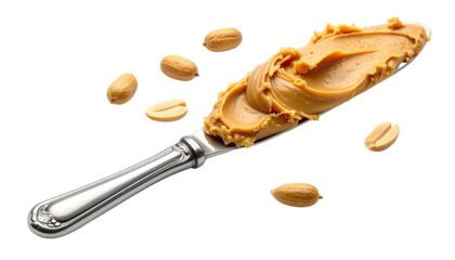 Close-up of smooth, creamy peanut butter spread on a silver knife, with scattered peanuts