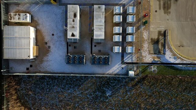 Aerial view of CNG cooling turbines and fans, a landscape of industrial geometry and winter's touch, contrasting hard structures with soft snow, Corby, United Kingdom.