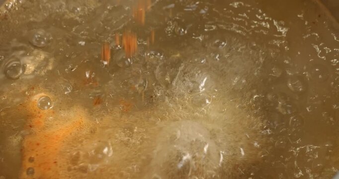 Spices are poured into boiling water, the process of cooking Korean spicy instant noodle soup ramyong.
