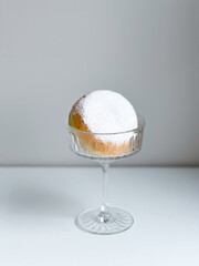 Donut with powdered sugar  in a glass on a white background