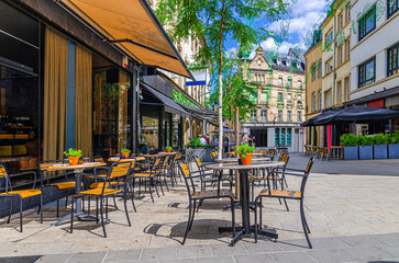 Street restaurant with tables and chairs on pedestrian street in old town Ville Haute quarter Luxembourg City historical centre, street cafe in old town