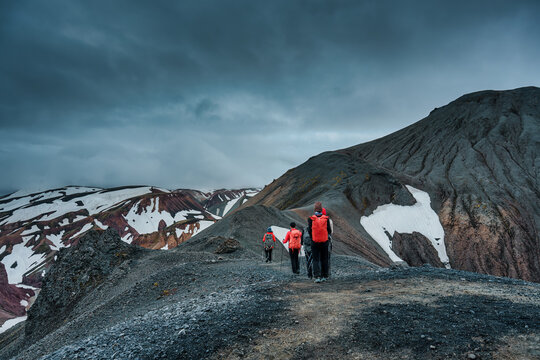 Group of hikers walking on volcanic mountain of Blahnukur trail in overcast at Landmannalaugar, Icelandic Highlands