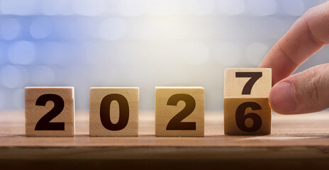 The transition from 2026 to 2027 on a wooden calendar. A conceptual image representing the new...