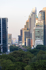 Modern office building and condominium with green tree Lumphini park sunset sky