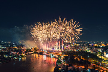 Spectacular fireworks display above Chao Phraya River, Memorial Bridge and Bangkok city at night