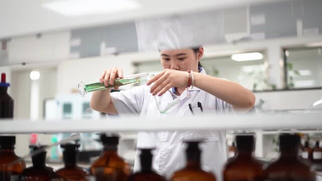 Pharmacist in laboratory carefully handling a reagent bottle during precise operation