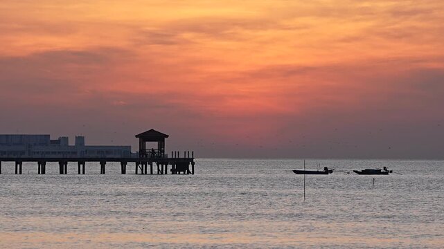 A large, round sun is rising from the sea this morning in Bang Pu District, Samut Prakan Province, Thailand.